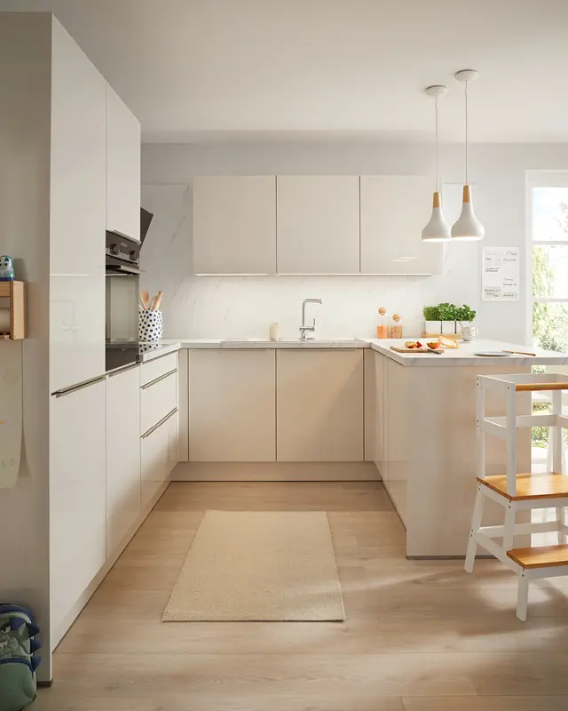 Helle Küche mit Halbinsel, weißen Fronten, Einbauofen, Pendelleuchten und hellem Teppich